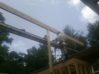 Carpenter setting a ridge beam over a new addition frame — Ice Dam Removal by Roofing Brothers in Yanceyville