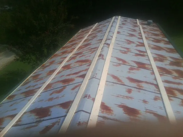 Rusted metal roof panels with new wood purlins before replacement — Storm Damage Roof Repair in Yanceyville by Roofing Brothers