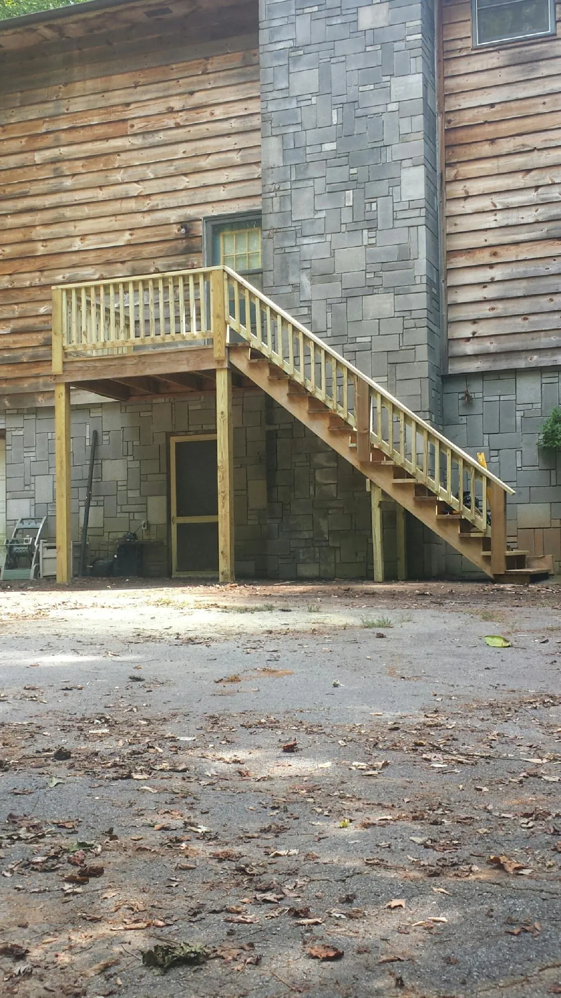 New pressure treated deck and stair landing on a log home in Yanceyville