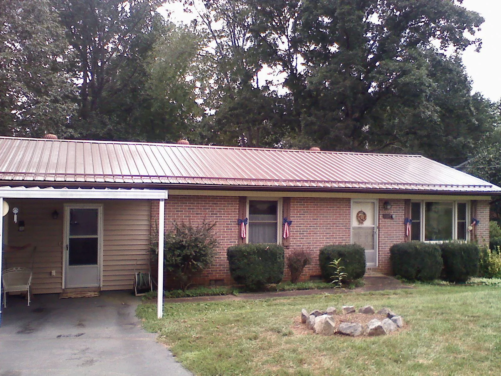 Bronze metal roof and carport on a brick ranch home — Roof Repair work by our crew in Yanceyville